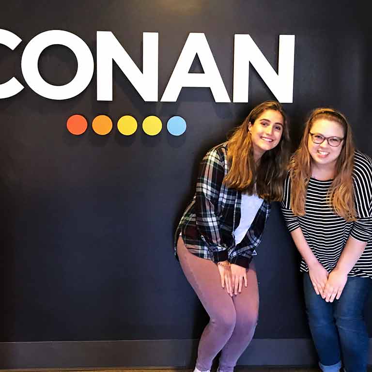 Two students stand in front of a sign for Conan for their Semester in Los Angeles.